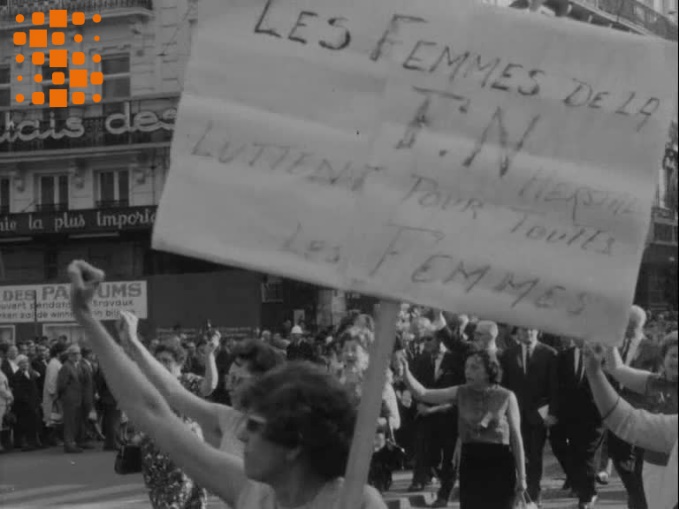 Archives Sonuma, Bulletin d’actualité, 1 mai 1966. Défilé du 1er mai 1966 à Bruxelles. Charlotte Hauglustaine fait ici figure de fer de lance du mouvement : le poing levé, tenant un calicot « les femmes de la FN Herstal luttent pour toutes les femmes », elle chante « Le travail, c’est la santé… ». Le montage du sujet d’actualité fait précéder et suivre ce portrait d’images de femmes qui, dans un champ-contrechamp, apparaissent comme les destinataires du geste et du chant de l’ouvrière de la FN. Cette séquence donne ainsi une certaine envergure au mouvement de contestation tout en le circonscrivant à des cercles féminins. 